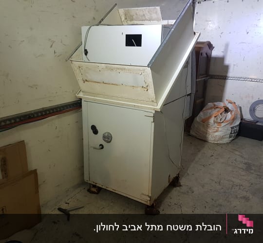 מכונה לבנה עם דלתות, כלים וקרטונים מסביב